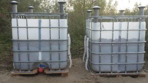 Two plastic tanks in metal cages on the outside.